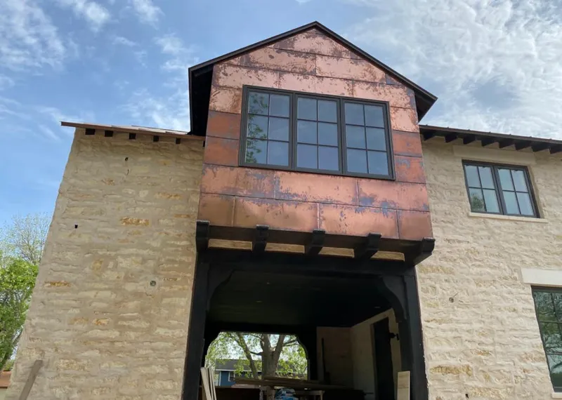 Copper metal panel facade on a stone building for Skylight Installation in Hamlet